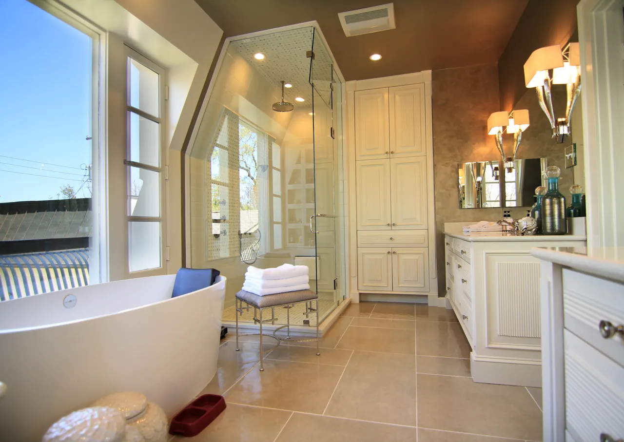 Large primary bath with white painted cabinetry, glass shower and freestanding tub