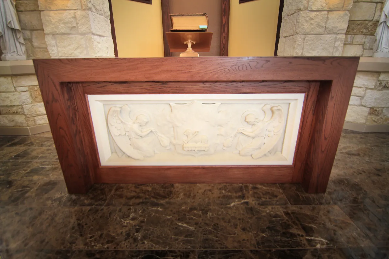 Wood altar with a carved stone relief panel set into its face