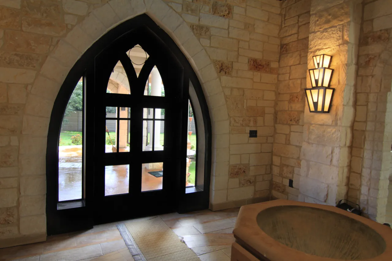 Pointed arch wood and glass door with tracery in a limestone wall
