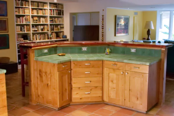 Curved two-level knotty alder island with green tile and a wood bar top