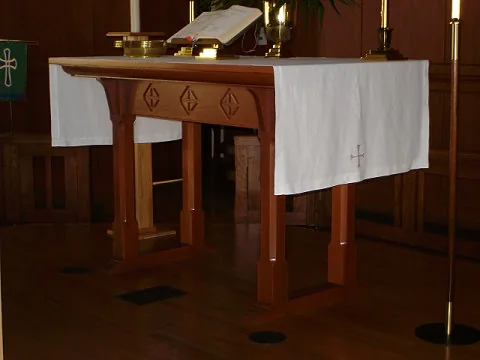 Arts and Crafts style wood altar table with carved emblems